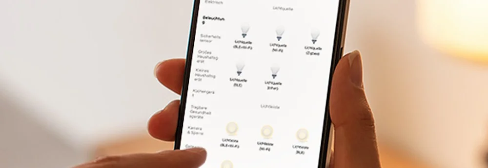 Person steuert Smart Home Beleuchtung über Smartphone